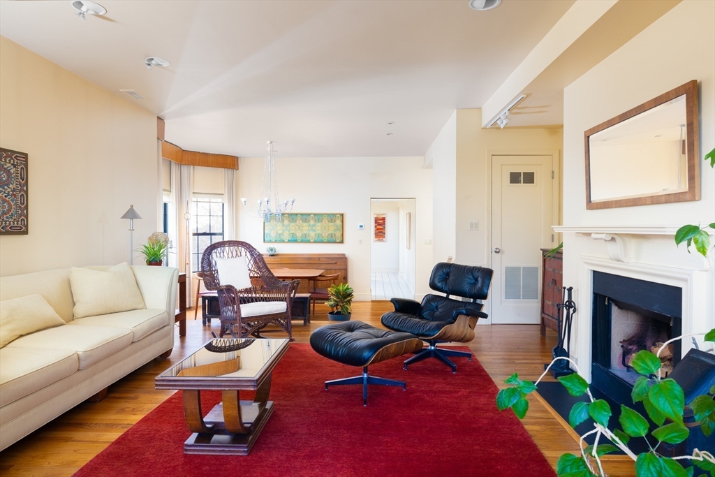 227 Summit Avenue, Unit E405 Brookline, MA 02446 - Photo 4 of 15 a living room with furniture a fireplace and a table