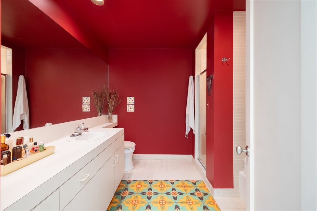 227 Summit Avenue, Unit E405 Brookline, MA 02446 - Photo 10 of 15 a bathroom with a sink a mirror and a vanity