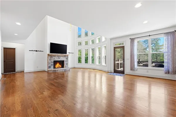 a view of empty room with fireplace and wooden floor