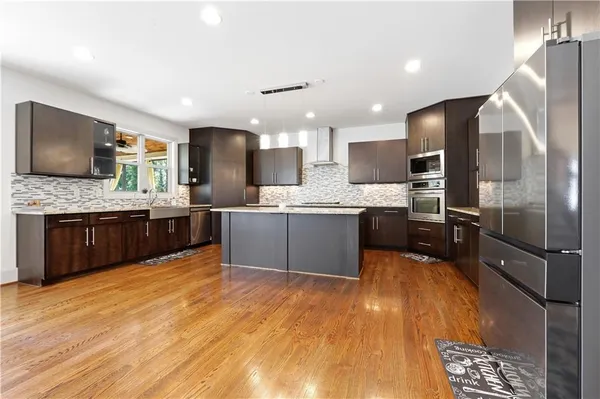 a large kitchen with a center island and stainless steel appliances