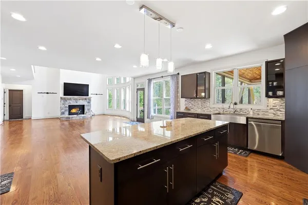 a large kitchen with stainless steel appliances a large counter top a stove a sink a refrigerator and a microwave