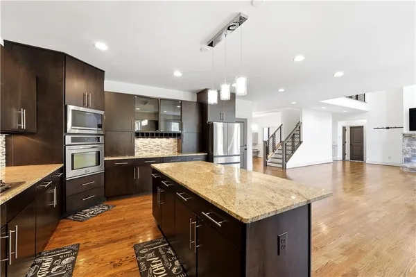 a kitchen with granite countertop kitchen island a sink appliances and a counter top space