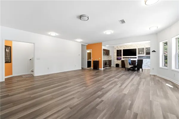 a kitchen with a table chairs refrigerator and microwave