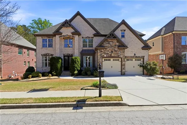 a front view of a house with a garden and parking