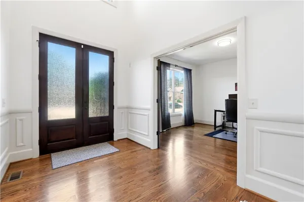 a view of a hallway with wooden floor and furniture and windows