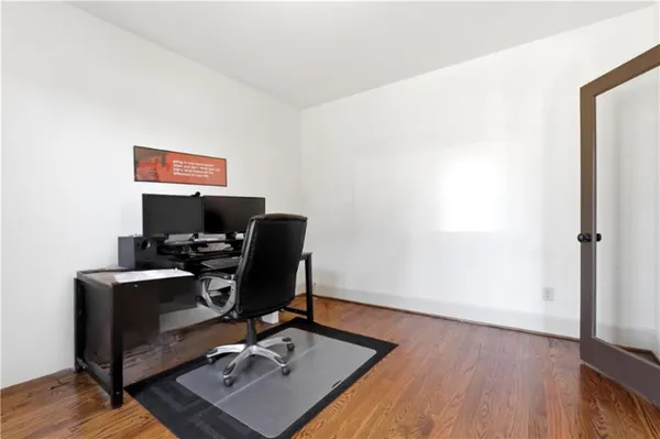 a view of a workspace with furniture and wooden floor
