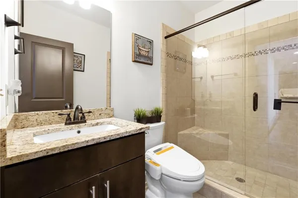 a bathroom with a granite countertop sink toilet and shower