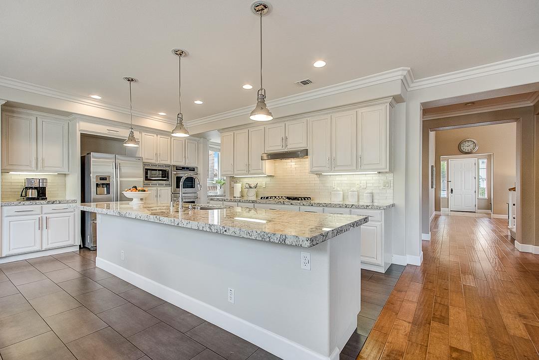 7108 Lahinch Drive Gilroy, CA 95020 - Photo 12 of 50 a large kitchen with granite countertop a large counter top a sink stainless steel appliances and cabinets