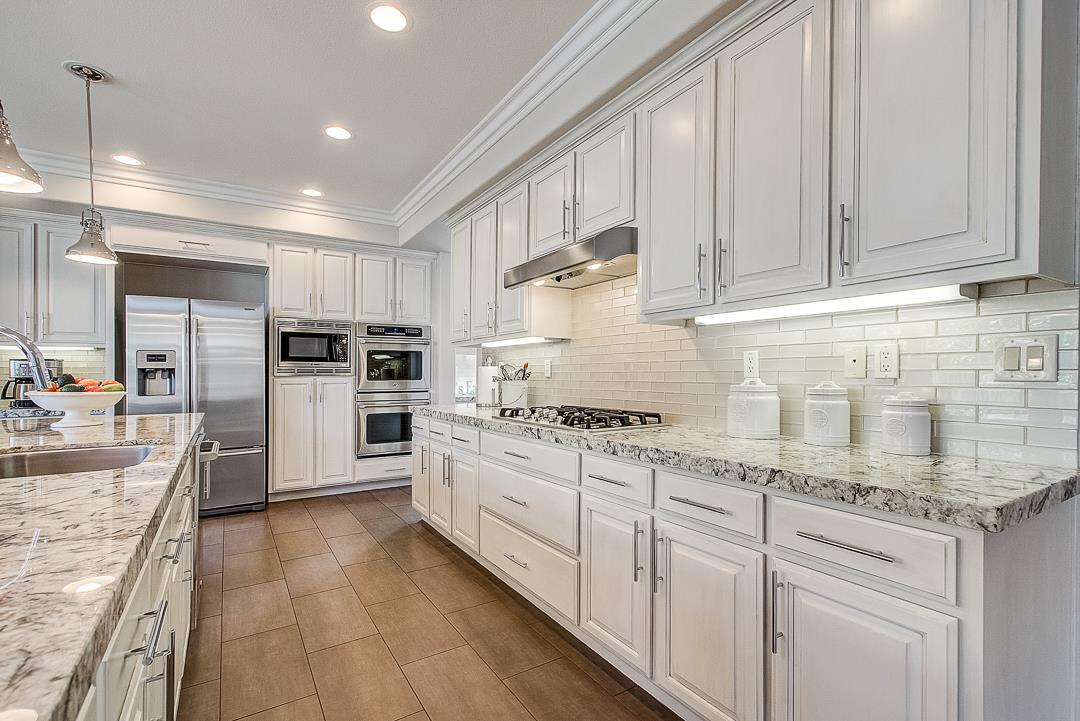 7108 Lahinch Drive Gilroy, CA 95020 - Photo 13 of 50 a kitchen with stainless steel appliances granite countertop a stove sink and cabinets
