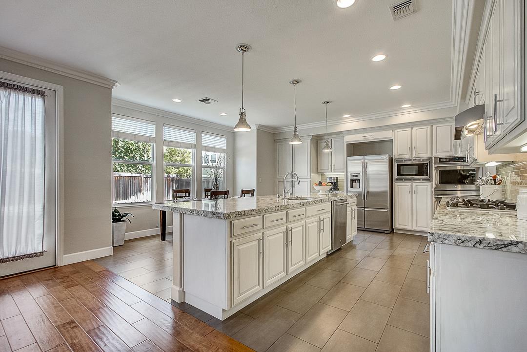 7108 Lahinch Drive Gilroy, CA 95020 - Photo 15 of 50 a large kitchen with kitchen island a large counter top space a sink stainless steel appliances and cabinets