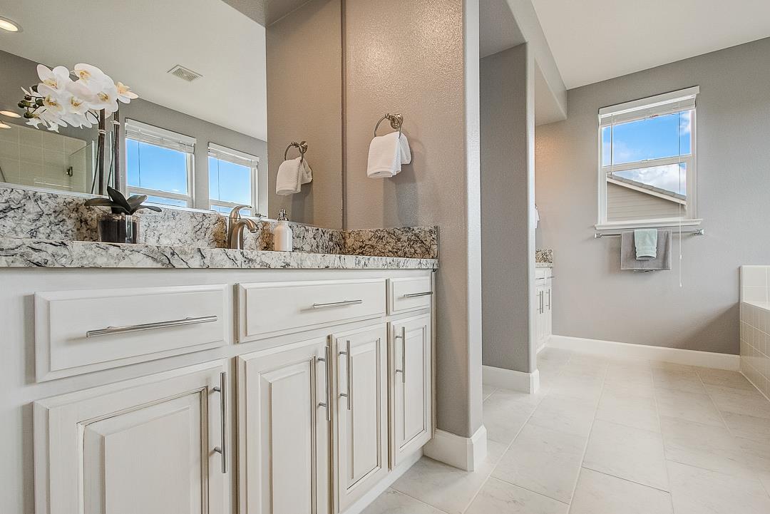 7108 Lahinch Drive Gilroy, CA 95020 - Photo 32 of 50 a bathroom with a granite countertop sink a mirror and a vanity