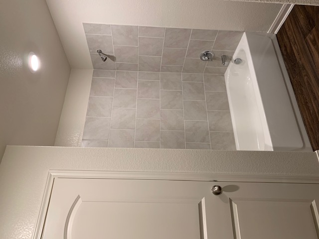 140 Allington Circle Jarrell, TX 76537 - Photo 12 of 23 Bathroom with shower / bathtub combination, a textured wall, and dark wood finished floors