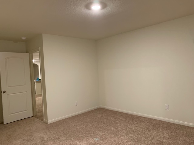 140 Allington Circle Jarrell, TX 76537 - Photo 14 of 23 Empty room featuring baseboards and light carpet