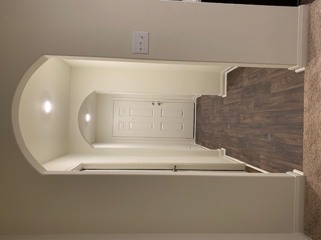 140 Allington Circle Jarrell, TX 76537 - Photo 18 of 23 Hallway featuring arched walkways, dark wood-style floors, and dark carpet