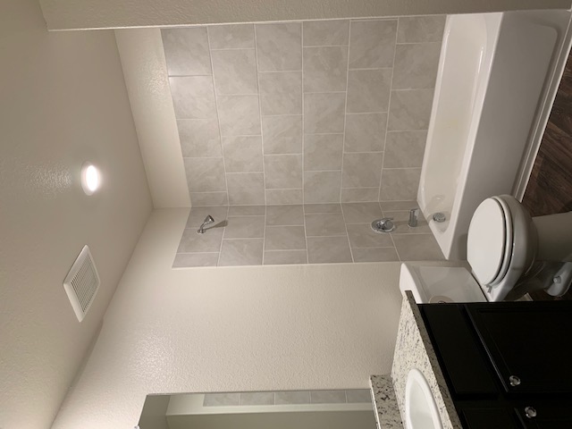 140 Allington Circle Jarrell, TX 76537 - Photo 22 of 23 Bathroom with shower / bath combination, a textured wall, vanity, and dark wood-style flooring