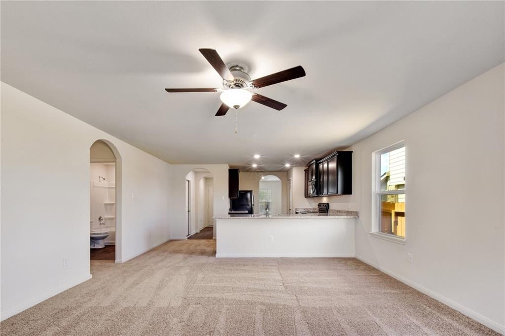 140 Allington Circle Jarrell, TX 76537 - Photo 23 of 23 Unfurnished living room with light carpet, ceiling fan, and arched walkways
