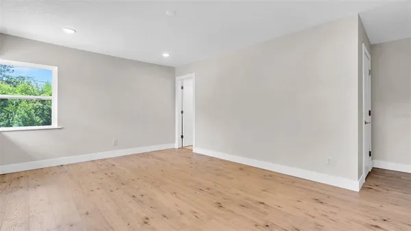 a view of a livingroom with wooden floor and staircase