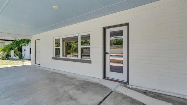 a view of a yard with potted plants and large trees