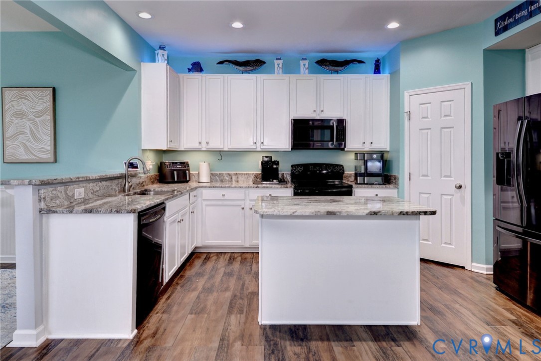 8428 Sheldon Branch Place Toano, VA 23168 - Photo 11 of 46 a kitchen with kitchen island granite countertop a sink a counter top space stainless steel appliances and cabinets