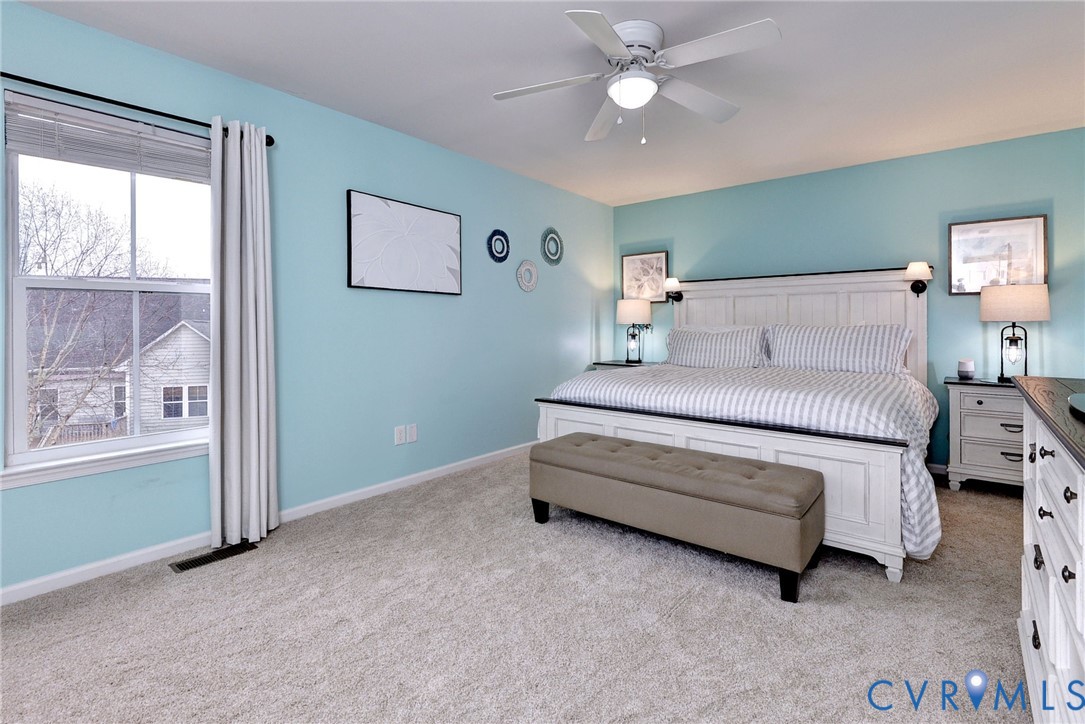 8428 Sheldon Branch Place Toano, VA 23168 - Photo 21 of 46 a bedroom with a bed chandelier and a window