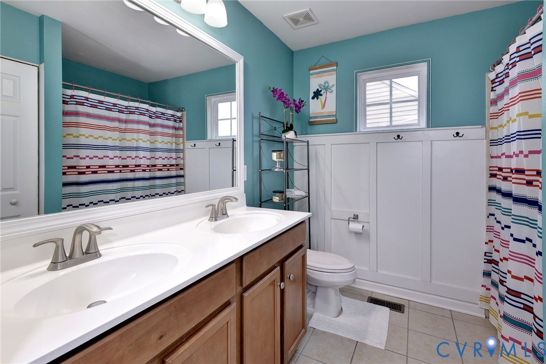 8428 Sheldon Branch Place Toano, VA 23168 - Photo 23 of 46 a bathroom with a sink a toilet and a large mirror