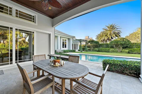 a view of a swimming pool with a table and chairs in patio