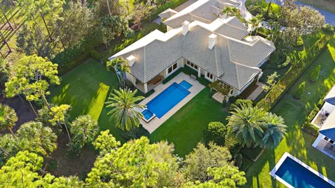 a view of swimming pool with a lounge chair and trees in the background