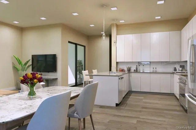 a white kitchen with kitchen island a dining table and chairs