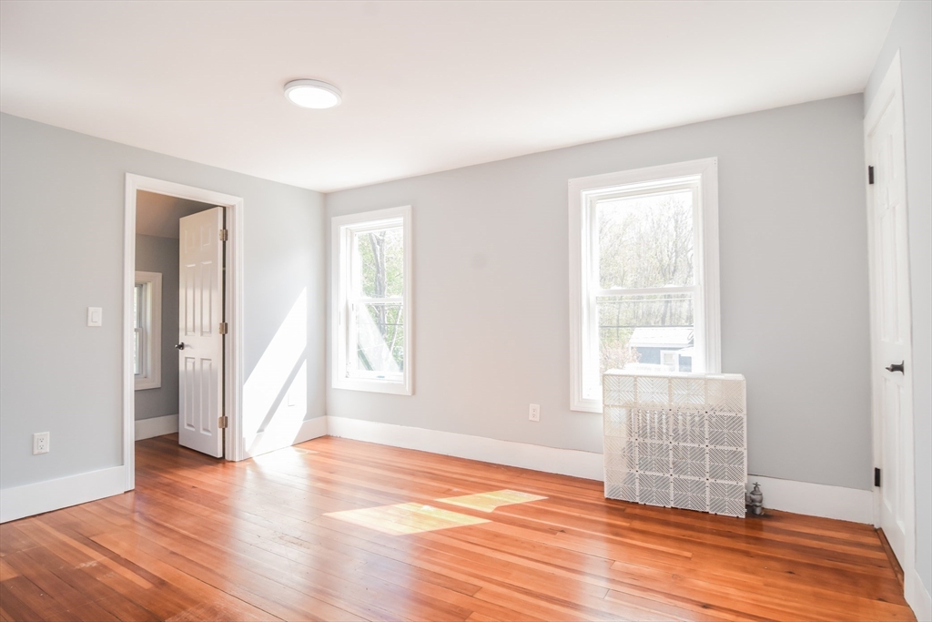 13 Crump Street Hudson, MA 01749 - Photo 20 of 33 an empty room with wooden floor and windows