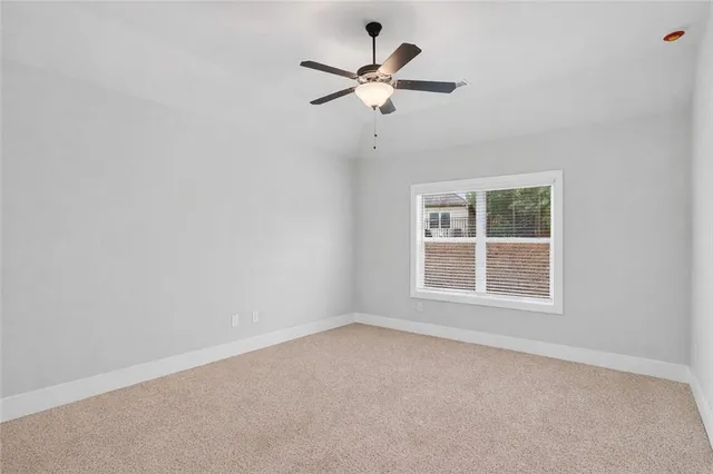 an empty room with a window and a fan