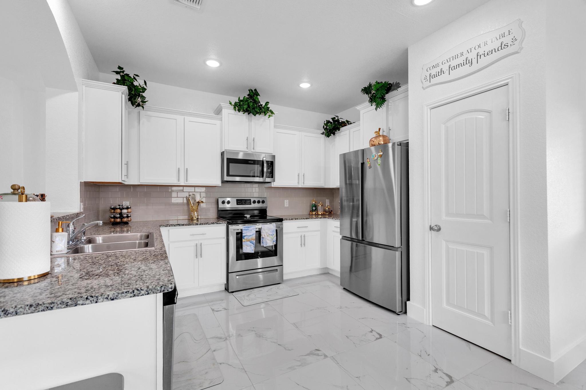 119 Beth Ann Loop Taylor, TX 76574 - Photo 12 of 31 A well-appointed kitchen features polished white cabinetry, sleek granite countertops, and modern stainless steel appliances.