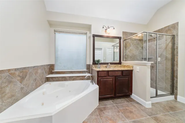 a bathroom with a granite countertop sink mirror and a bathtub