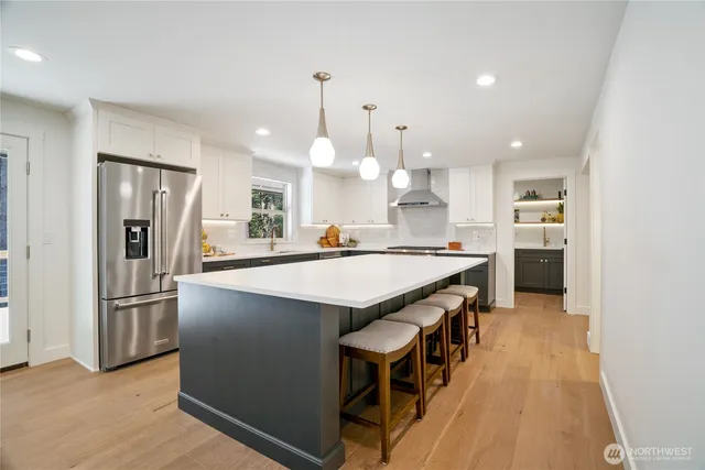 a kitchen with kitchen island a counter top space a sink stainless steel appliances and cabinets