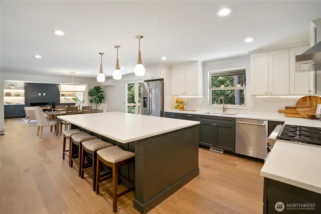 a kitchen with a stove a sink dishwasher a kitchen island with wooden cabinets and floor