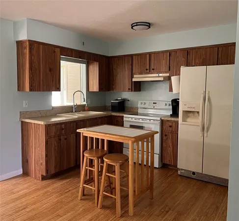 a kitchen with stainless steel appliances granite countertop a white cabinets and a refrigerator