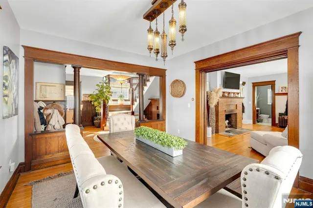 a living room with furniture dining table a large window with wooden floor