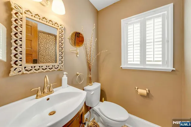 a bathroom with a sink mirror and a toilet