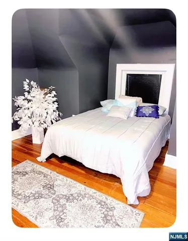 a bedroom with a bed and a painting on the wall