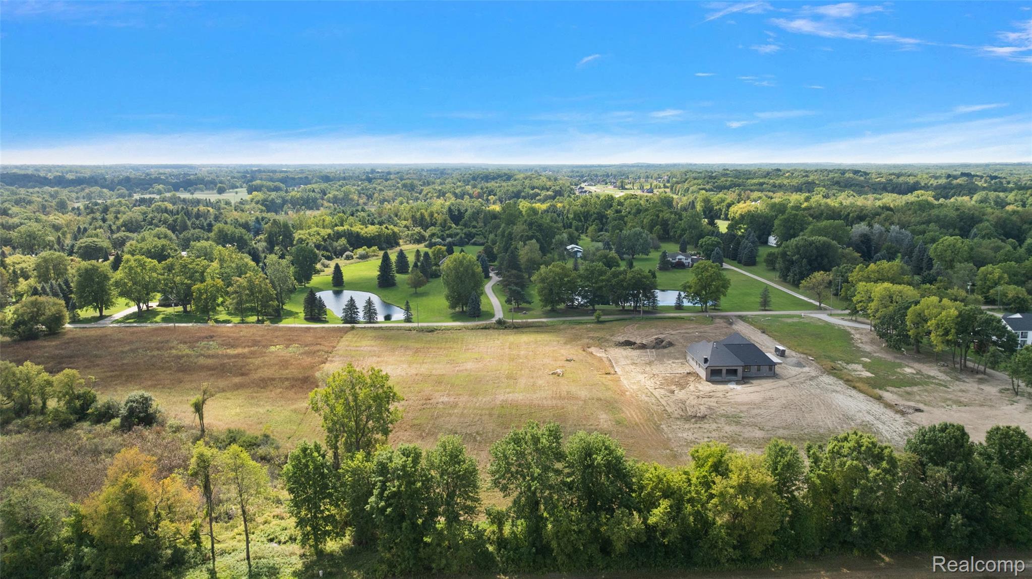 4059 Taft Road Romeo, MI 48065 - Photo 15 of 59 Expansive lot with partial land clearing, surrounded by mature trees, and a partially constructed residence