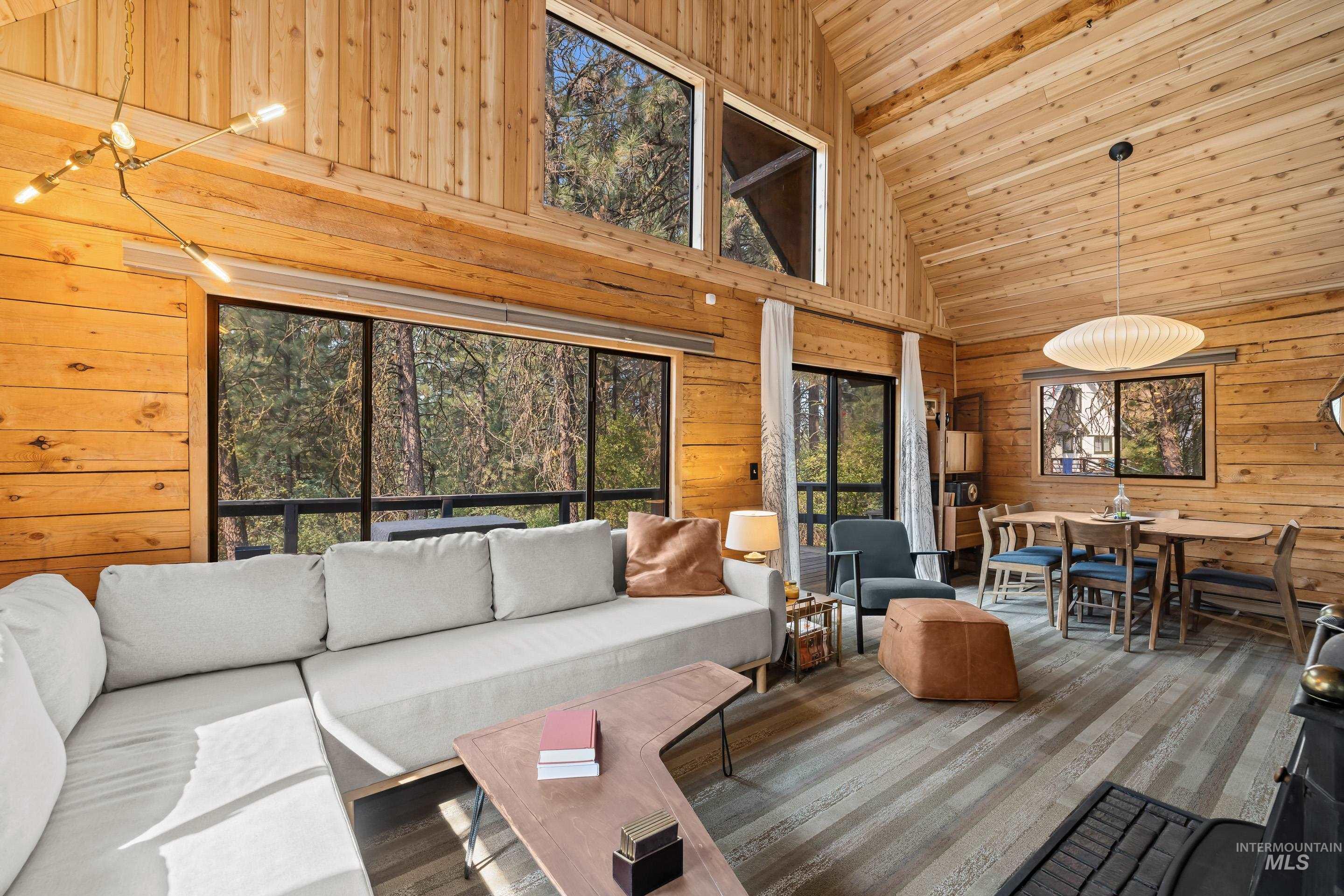 73 Rainbow Ridge Road Garden Valley, ID 83622 - Photo 27 of 49 Vaulted wood-paneled ceilings, expansive windows, wood-finish flooring, and a contemporary linear chandelier