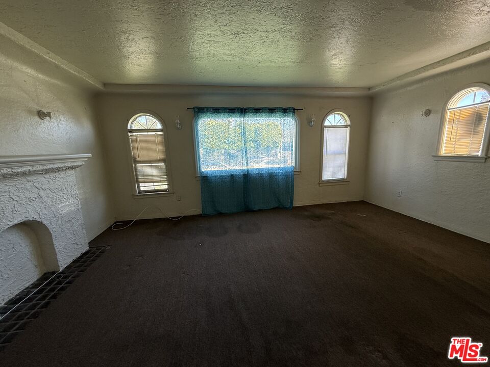 1415 North Spring Avenue Compton, CA 90221 - Photo 17 of 24 an empty room with a fireplace and windows