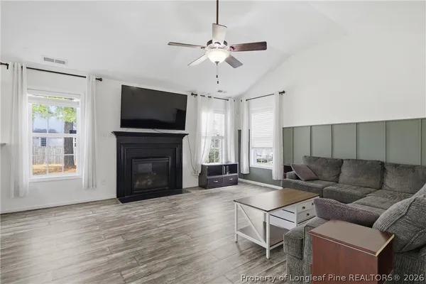 a living room with furniture a flat screen tv and a fireplace