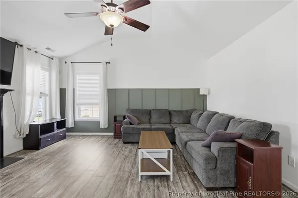 a living room with furniture and a wooden floor