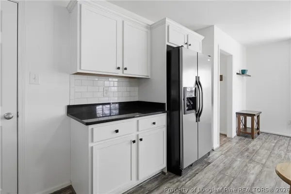 a kitchen with granite countertop a refrigerator sink and cabinets