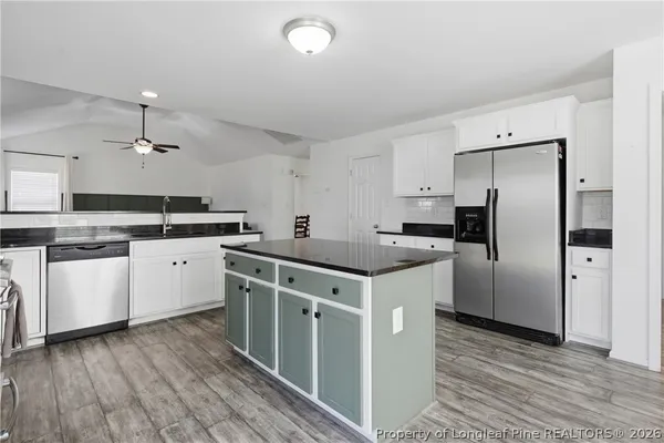 a kitchen with stainless steel appliances a stove a sink and a refrigerator