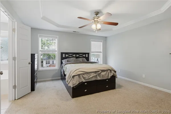 a spacious bedroom with a bed and a ceiling fan