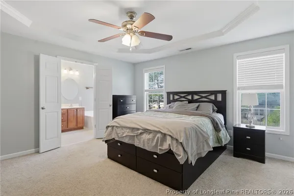 a spacious bedroom with a bed and a chandelier