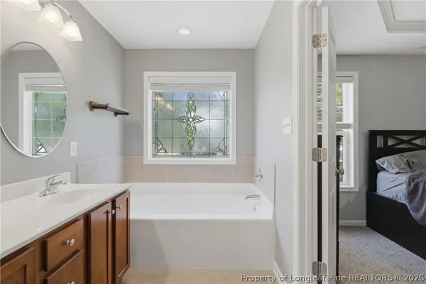 a bathroom with a tub sink and mirror