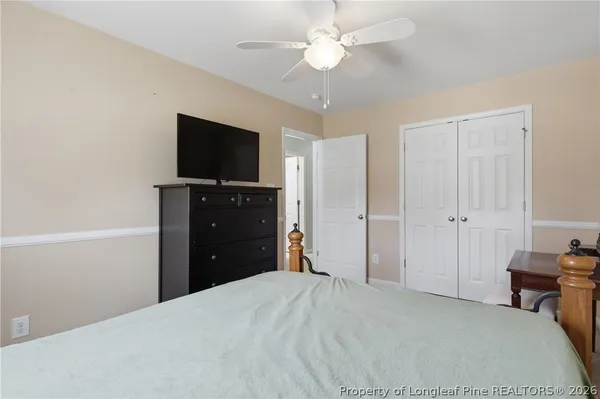 a bedroom with a bed and a flat tv screen on dresser