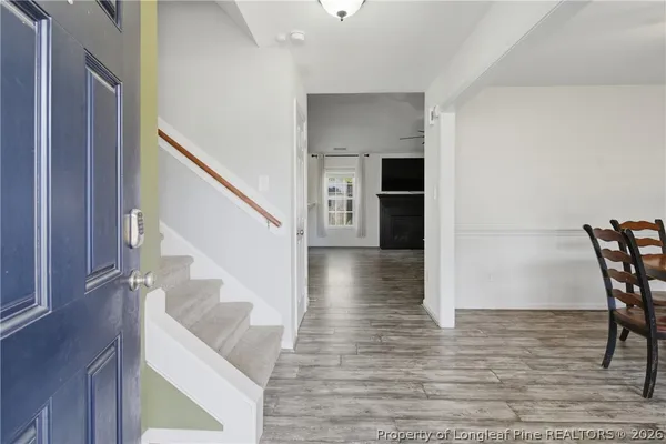 a view of a hallway with wooden floor and staircase